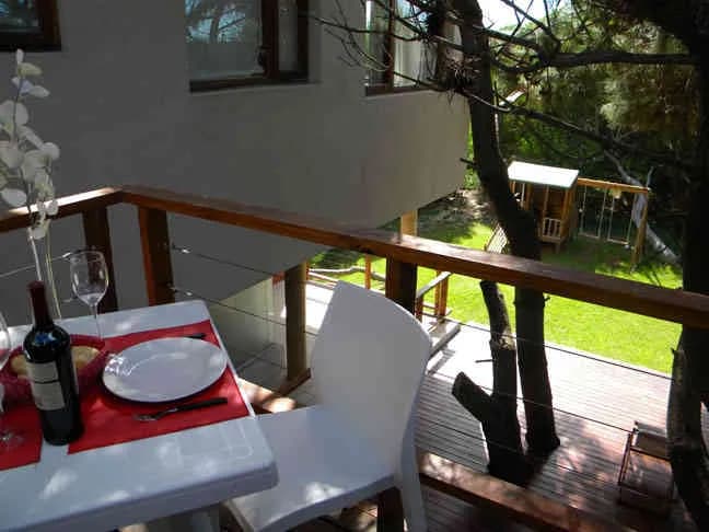 La mesa puesta en el balcón, entre los pinos
