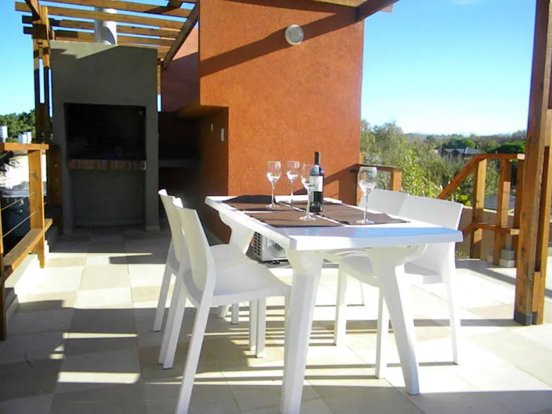 La terraza con parrilla y mesa de exterior